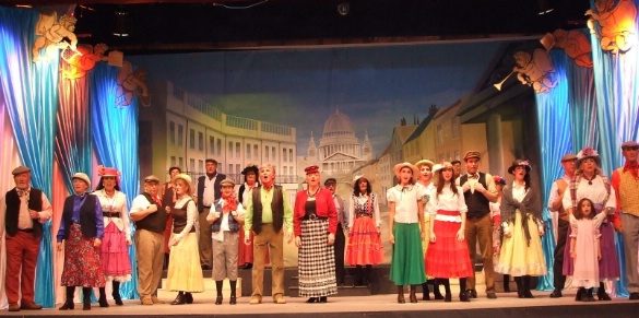 A colorful stage performance featuring a large cast in costumes at Salon Varietés Theatre.