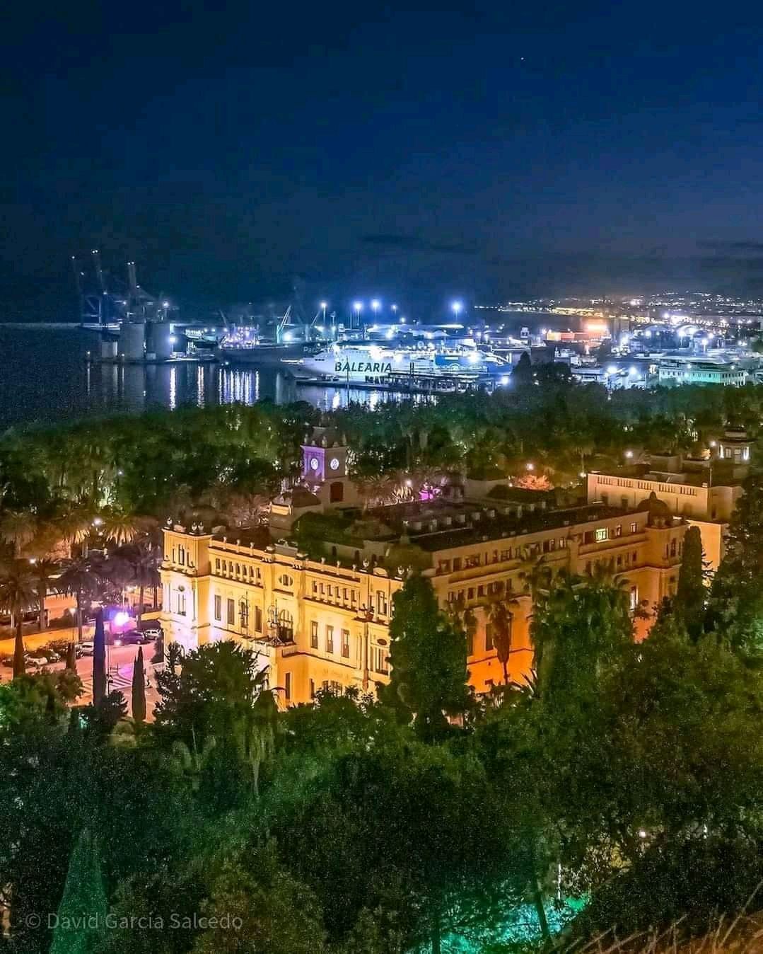 Night view of the port area with illuminated buildings and greenery in Antequera, Málaga.