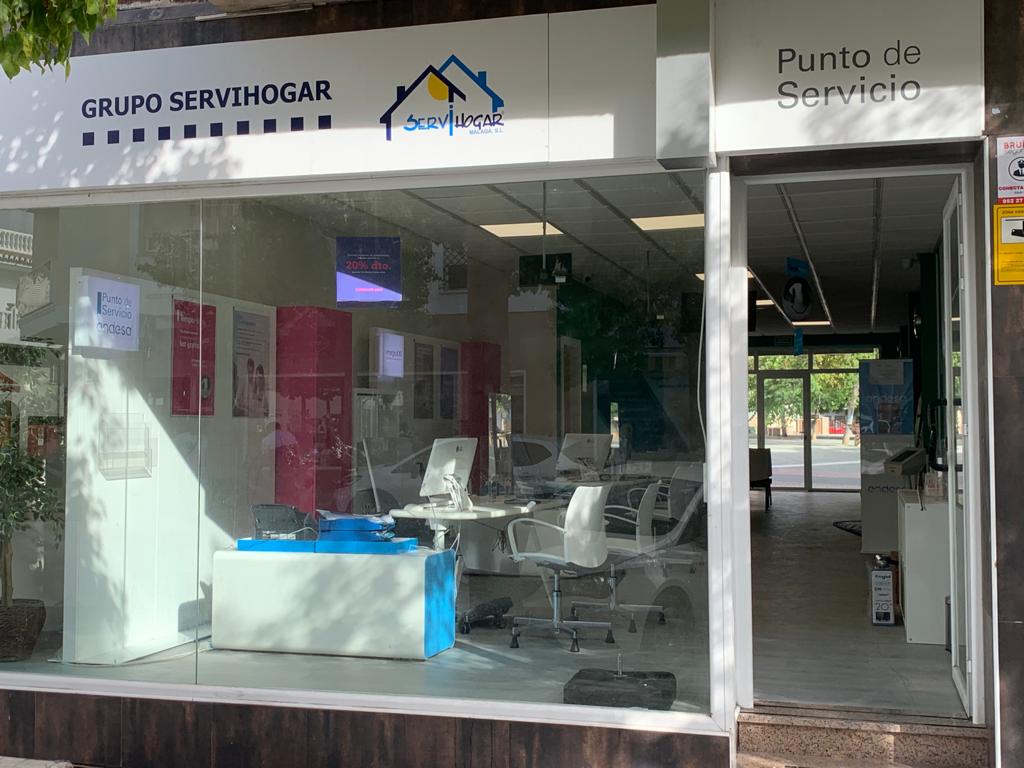 Exterior view of SERVIHOGAR MÁLAGA office with a modern design and large windows showcasing the interior workspace.