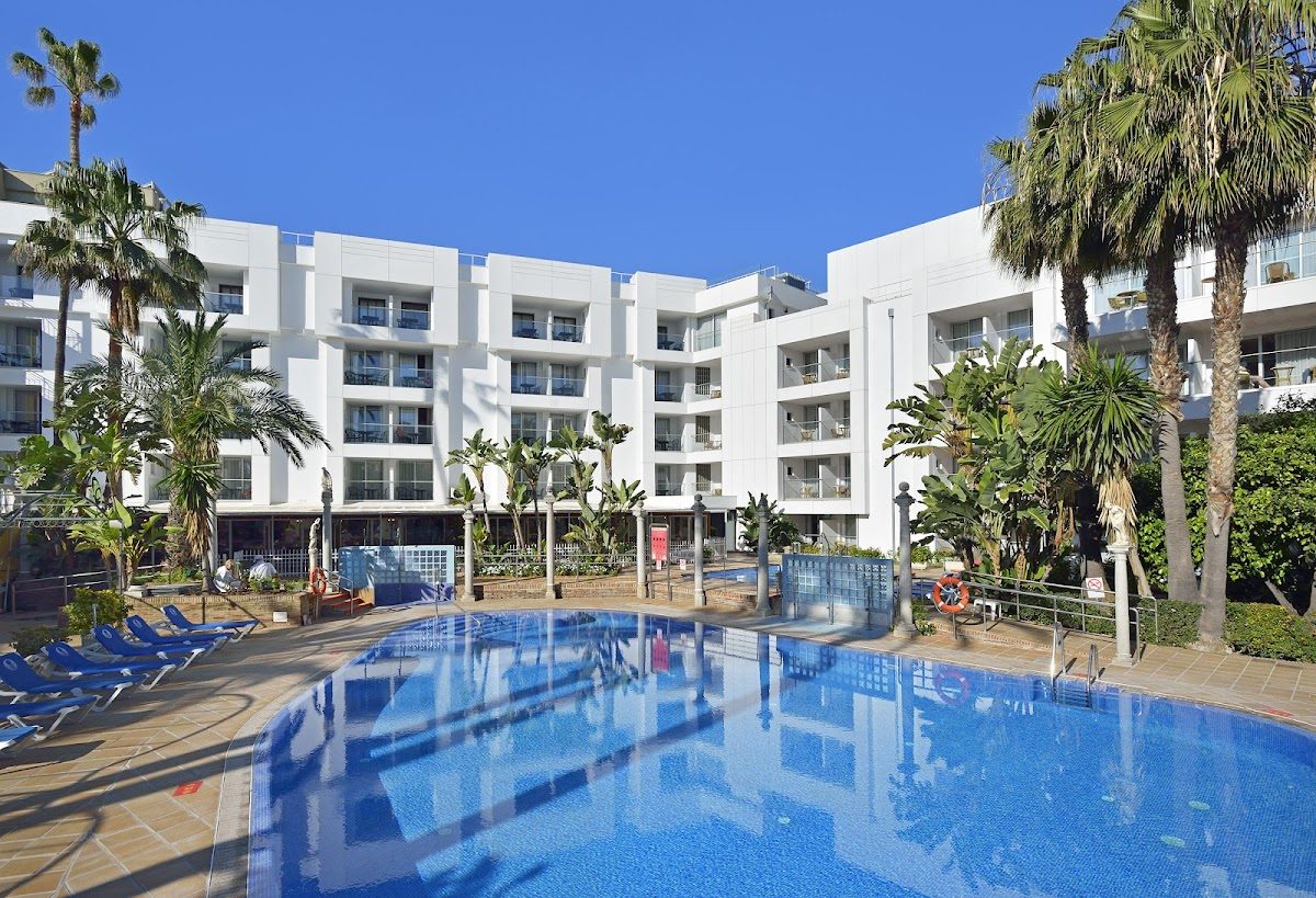 Sol Torremolinos - Don Pedro features a large outdoor pool surrounded by palm trees and lounge chairs.