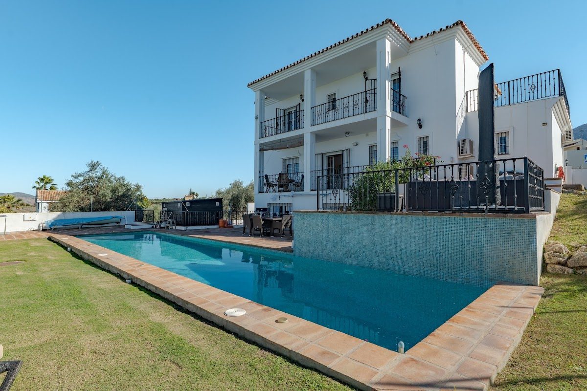 Una espaciosa villa blanca con piscina y zona de estar al aire libre en Alhaurín el Grande.