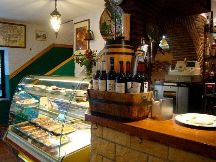 El interior de la Taberna TIERRARANDA cuenta con una vitrina con diversos platos y un barril de madera con botellas de vino.