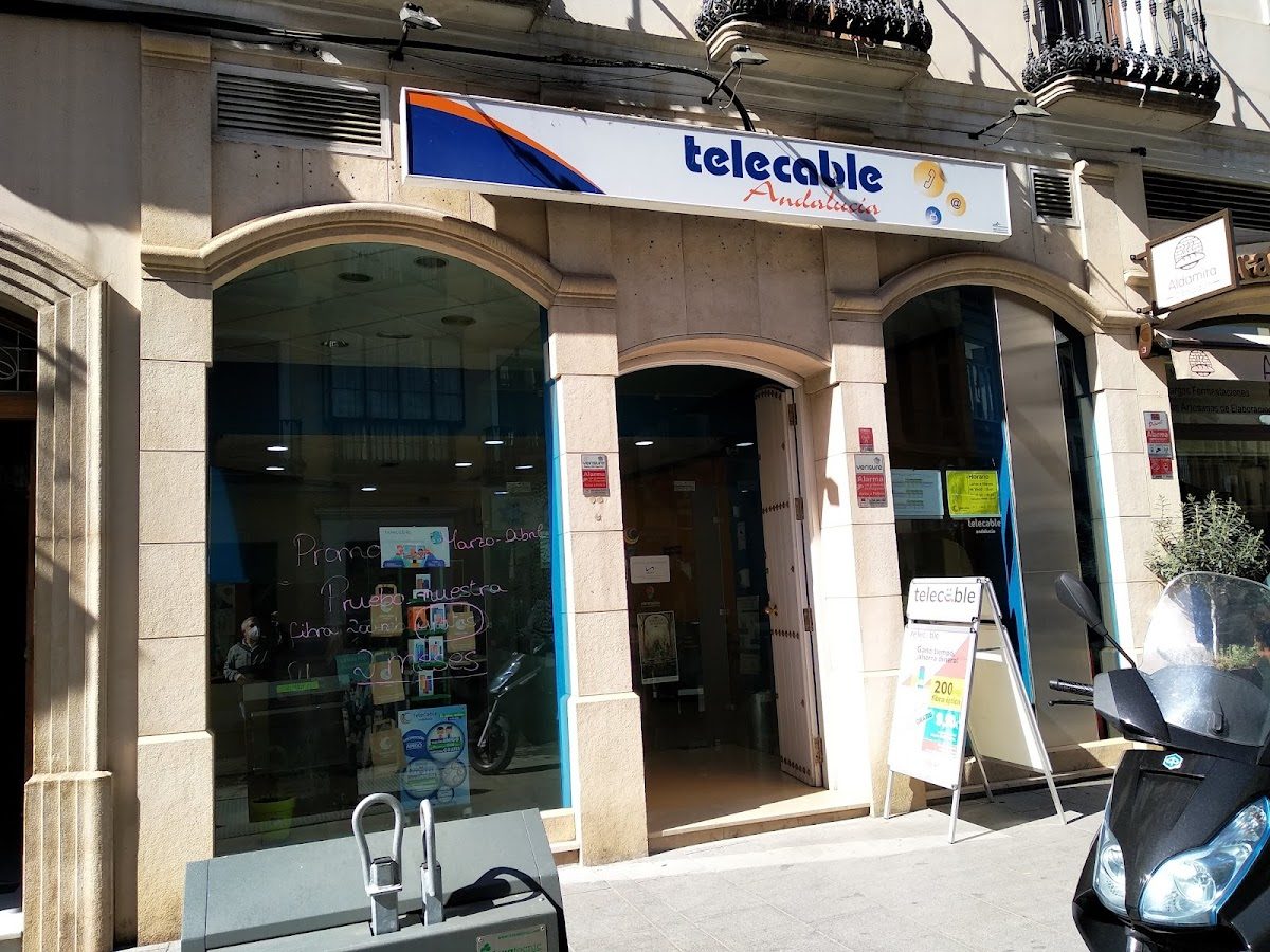 Telecable Andalucia storefront with large windows, signage, and a scooter parked outside.