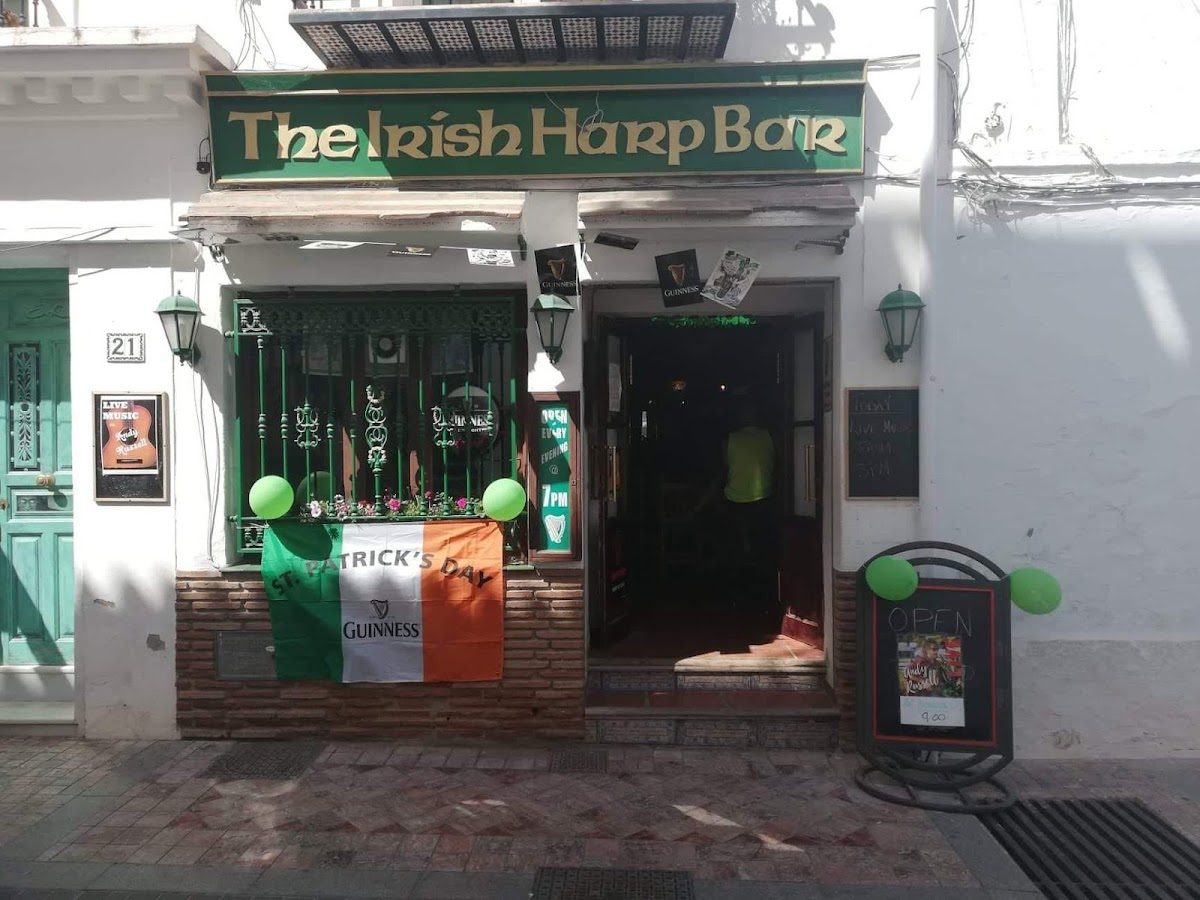 The Irish Harp Bar features a festive exterior with green decorations and a St. Patrick's Day banner.