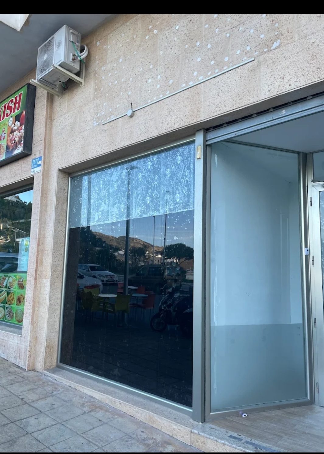 The exterior of The Mary Jane Asoc features a large glass window and a clean entrance.