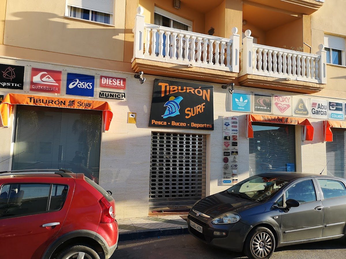 Tiburon Surf storefront features a vibrant sign and outdoor awnings, with parked cars in front.