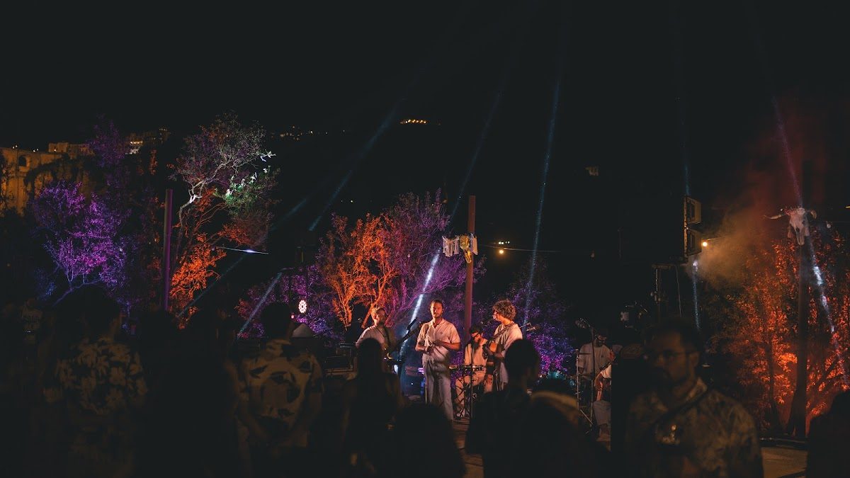 Tierra Fest features a vibrant outdoor stage with colorful lights and a live band performing at night.