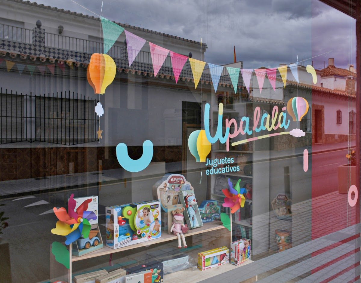 Colorful window display of Upalalá Juguetería featuring educational toys and decorative bunting.
