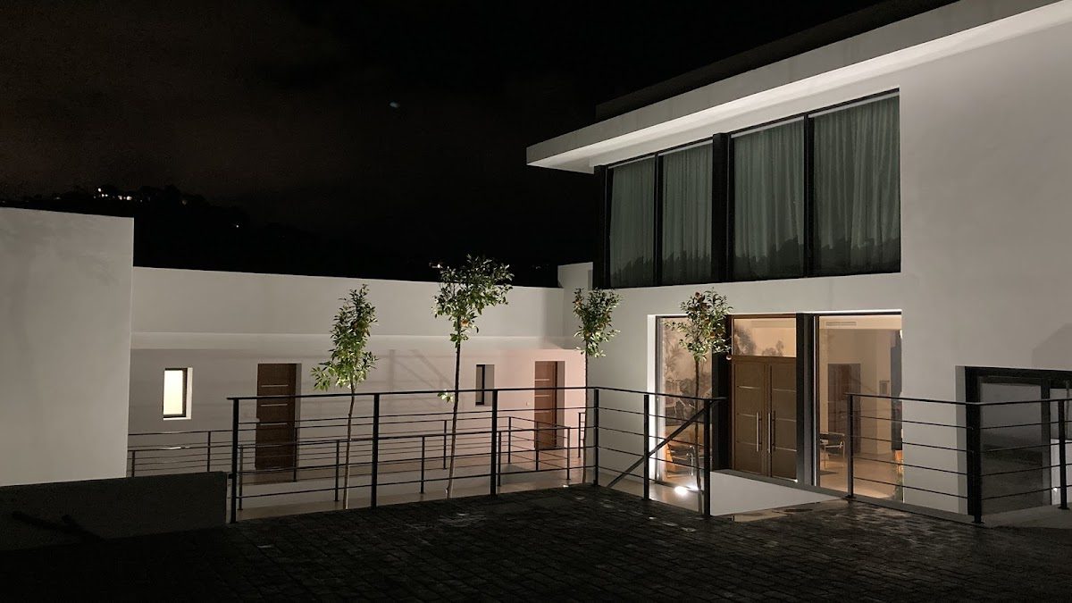 Modern exterior of Villa Azahar in Benahavís, featuring sleek architecture and illuminated entryway at night.